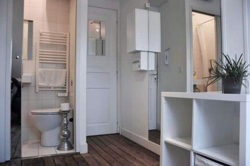La salle de bains blanche est pourvue de toilettes. dans l'établissement CENTRAL Paris Emplacement exceptionnel Nid coquet Tout EQUIPE salle de bains wc Vue Paris Climatisation Ascenseur, à Paris