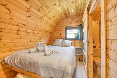 une chambre dans une cabane en rondins avec un lit dans l'établissement Ôtonneauxstress - Plagiste, à Saint-Vivien-de-Médoc