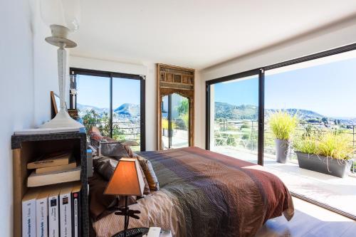 une chambre avec un grand lit et de grandes fenêtres dans l'établissement Villa Les Sources VI4245 By Riviera Holiday Homes, à Nice