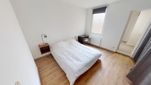 une chambre avec un lit blanc et une fenêtre dans l'établissement Marechal Joffre - RDC - Grand F2, au Havre