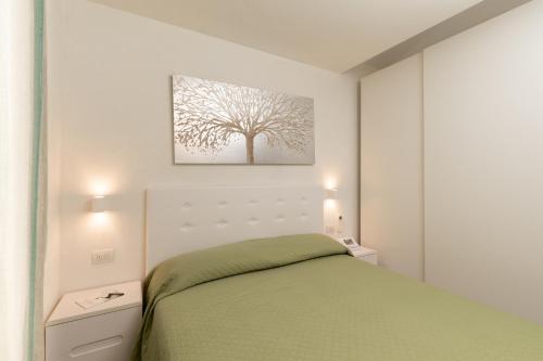 ein Schlafzimmer mit einem Bett und einem Baum an der Wand in der Unterkunft Villetta Otis by Wonderful Italy in San Teodoro