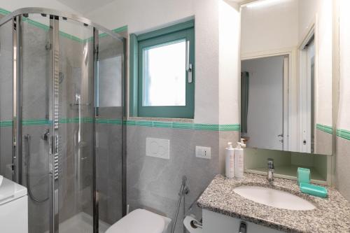 ein Badezimmer mit Dusche, Waschbecken und Toilette in der Unterkunft Villetta Otis by Wonderful Italy in San Teodoro
