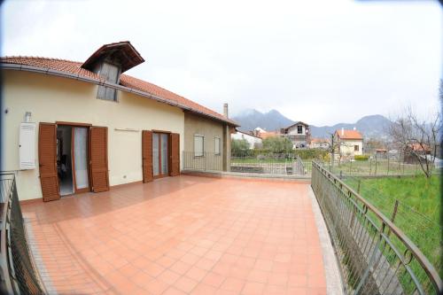 a house with a brick patio next to a fence at Da zio Antonio Rooms in Agerola