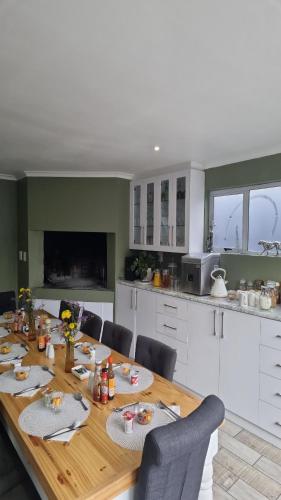a kitchen with a wooden table with chairs and a tableablish at Northern Vine Guesthouse B&B Self-catering in Brackenfell