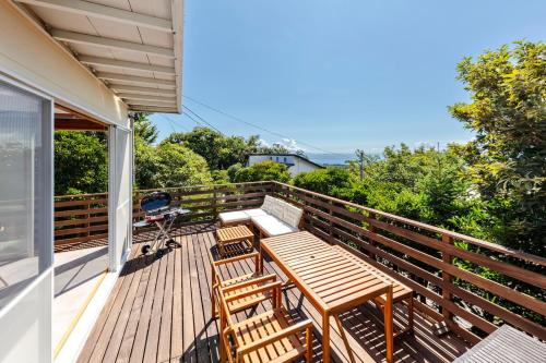 a deck with a wooden table and chairs on a house at Villa ORB in Ito