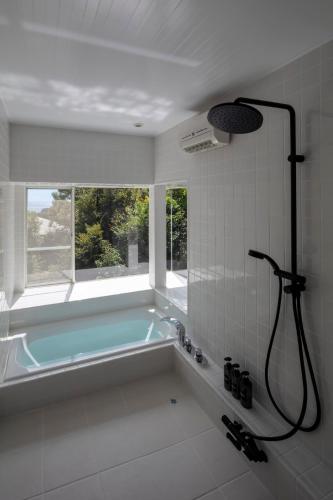 a bath tub in a bathroom with a window at Villa ORB in Ito