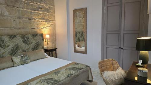 a bedroom with a bed and a table and a chair at La Gitanilla Alojamiento & Encanto Jerez in Jerez de la Frontera