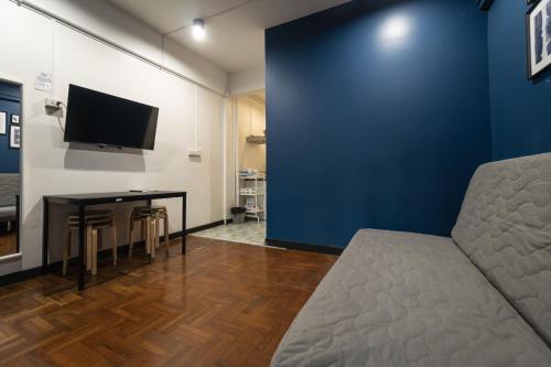 a room with a couch and a table and a tv at T4 Two Bedrooms Full kitchen/1 min to BTS in Bangkok