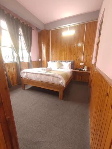 a bedroom with a large bed with wooden walls at Spicy Bristo, Silent Dragon Inn in Sonāda