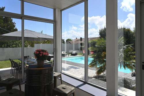 Cette maison dispose de fenêtres offrant une vue sur la piscine. dans l'établissement La Villa Palmier - Piscine avec Grand Jardin, à Meschers-sur-Gironde