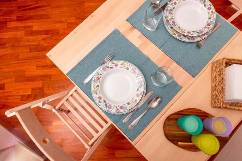 a table with plates and silverware on top of it at Casa Marina in Pesaro