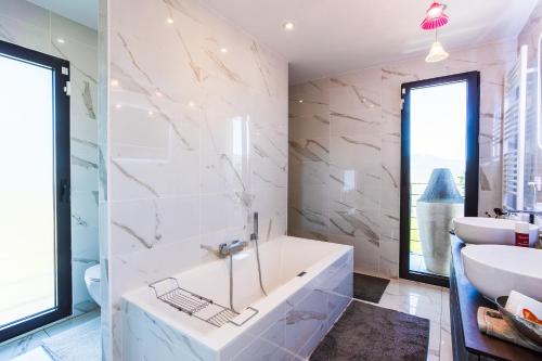 une salle de bain avec une baignoire et un lavabo dans l'établissement Villa Les Sources VI4245 By Riviera Holiday Homes, à Nice