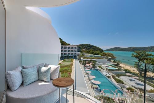 a balcony with a couch and a view of the ocean at Veranda Resort Phuket, Autograph Collection in Panwa Beach