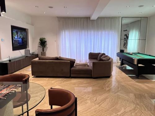 a living room with a couch and a pool table at Premium 3 bedroom apartment ikoyi in Lagos