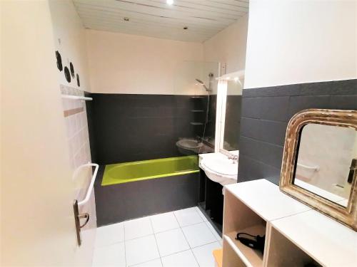 une salle de bain avec une baignoire verte et un lavabo dans l'établissement Appartement 110m2 Nice plein centre, à Nice