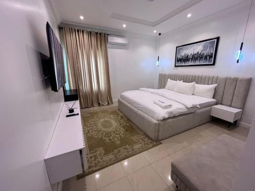 a bedroom with a bed and a flat screen tv at Premium 3 bedroom apartment ikoyi in Lagos