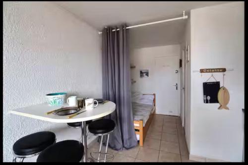 une pièce avec une table, des chaises et un lit dans l'établissement Studio MIMIZAN à 150m plage place du marché mimizan, à Mimizan