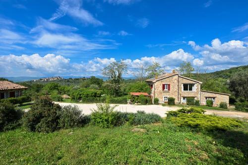 a stone house in the middle of a field at La Grande Via, ospitalità in Maremma in Montemerano