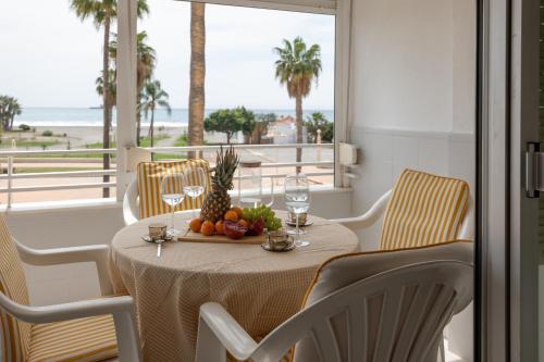 a table with fruit and wine glasses on a balcony at Comeback LOOKING FOR THE SUMMER in Motril