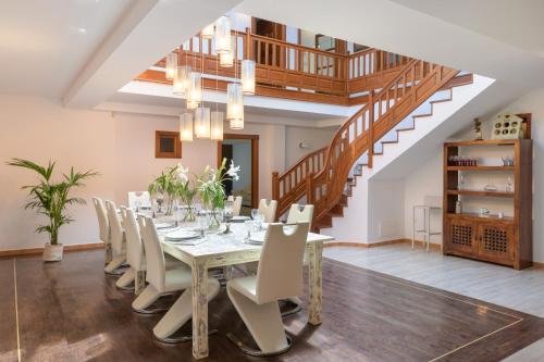 een eetkamer met een tafel en stoelen en een trap bij Spacious Private Villa up to 16 - Authentic Yaiza - Volcano, Timanfaya park, Bodega & South Beaches - Heated Pool - Game Room - Charcoal grill in Yaiza