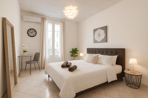 - une chambre avec un grand lit blanc et une horloge dans l'établissement Beautiful spacious air conditioned apartment - center, à Nice