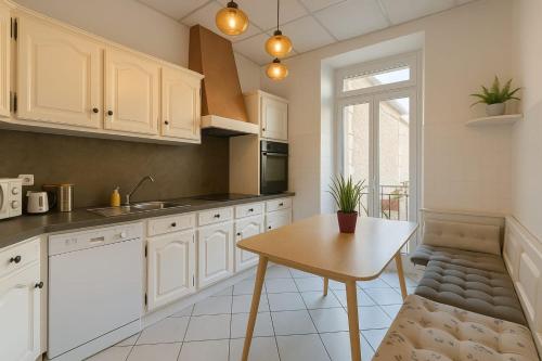 une cuisine avec des armoires blanches et une table en bois dans l'établissement Beautiful spacious air conditioned apartment - center, à Nice