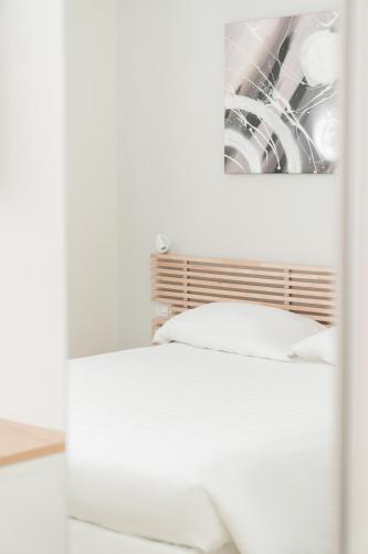 a white bed in a room with a picture on the wall at Dieci by Comorooms in Como