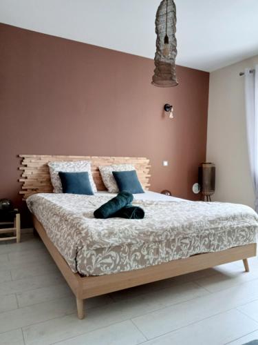 une chambre avec un grand lit avec des oreillers bleus dans l'établissement La villa du Pont du Gard, à Castillon-du-Gard