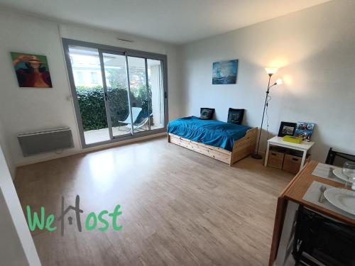 une chambre avec un lit et une grande fenêtre dans l'établissement Appartement résidence calme avec balcon, à La Rochelle