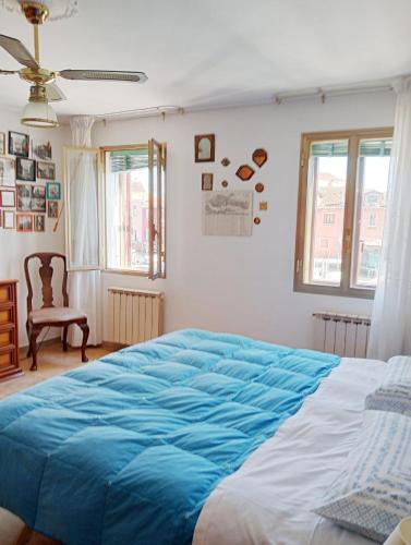 a bedroom with a large bed with a blue blanket at Appartamento vacanze Casadueottanta loc-13704 in Venice