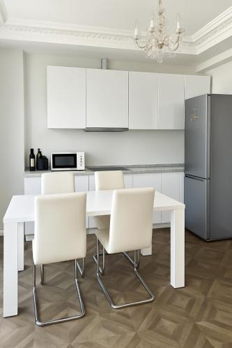 - une cuisine blanche avec une table et des chaises blanches dans l'établissement Splendide appartement design plein centre nice climatisé - 3 chambres, à Nice