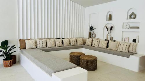a living room with a long couch and stools at K1 by Ceilao villas in Ahangama
