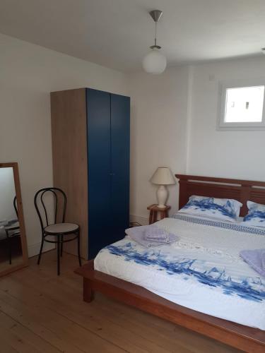 - une chambre avec un lit doté d'une armoire bleue et d'une chaise dans l'établissement Le Rivage, à Excenevex