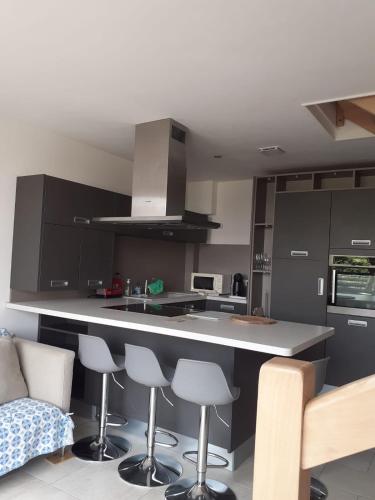 une cuisine avec un comptoir et quelques tabourets de bar dans l'établissement Le Rivage, à Excenevex