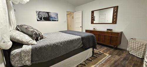 una camera da letto con un letto, un comò e uno specchio di Breathe Easy Here in Buda 3bd 2ba Home a Buda