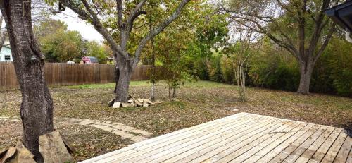 a yard with trees and a wooden walkway at Breathe Easy Here in Buda 3bd 2ba Home in Buda