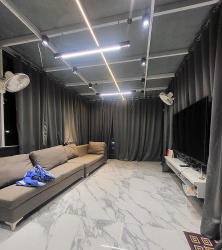 a living room with a couch and a flat screen tv at The Glass Home in Prayagraj