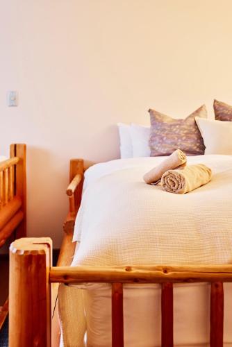 a bedroom with a bed with white sheets and pillows at Canopy Lodge - Boutique Lodge at Hakuba Cortina in Otari