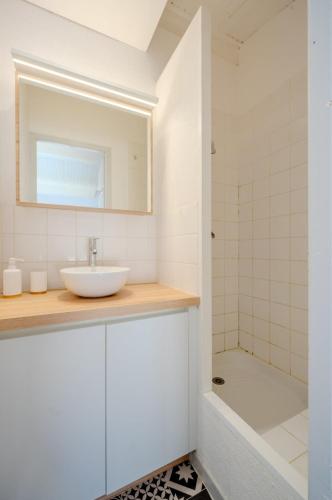 une salle de bain avec un lavabo et une douche dans l'établissement Appartement Samuel, à La Rochelle
