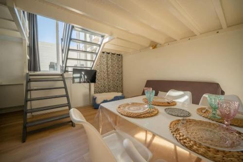 une chambre avec une table, des chaises et une échelle dans l'établissement Appartement Samuel, à La Rochelle