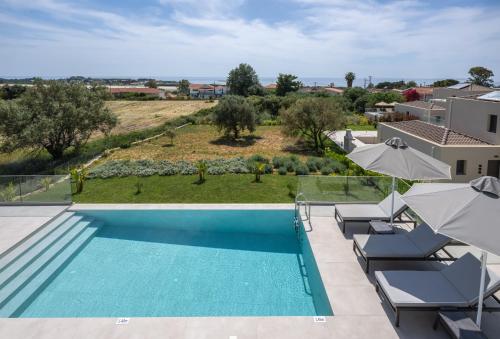 a pool with chairs and umbrellas in a villa at Villa Myrto - Elysian Villas Kefalonia, 200m from Beach, New 2024 in Minia