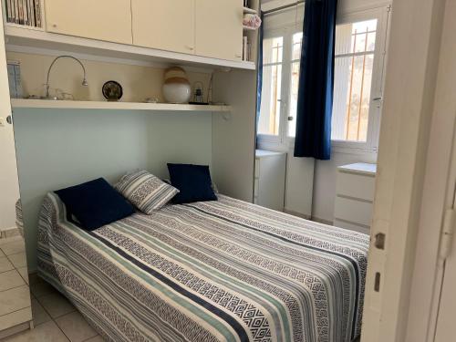 une chambre avec un lit avec des oreillers bleus dessus dans l'établissement Appartement avec superbe terrasse pour 4 personnes, au Lavandou