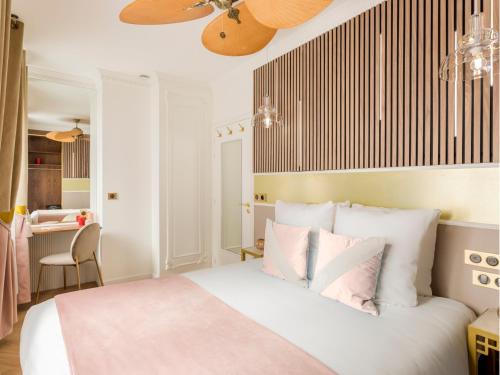 une chambre avec un lit blanc avec des oreillers roses dans l'établissement Merveil - Luxury Suite - Notre Dame - Boulangers, à Paris