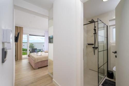 a bathroom with a shower and a bedroom with a bed at Villa Lada by Istrialux in Ladići
