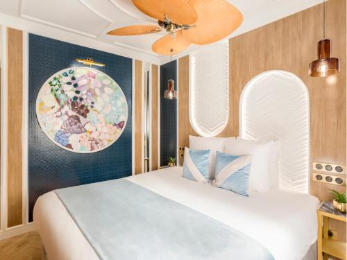 une chambre avec un lit blanc et un tableau au mur dans l'établissement Merveil - Luxury Suite - Notre Dame - Boulangers, à Paris