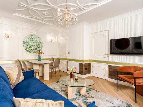 un salon avec un canapé bleu et une table dans l'établissement Merveil - Luxury Suite - Notre Dame - Boulangers, à Paris