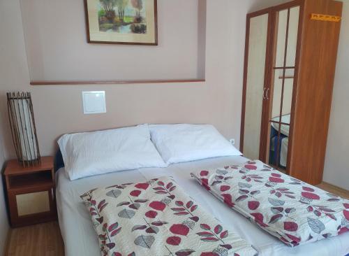a bed with a blanket on it in a bedroom at Apartman a Déliparton in Szántód