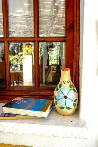 a book and a vase sitting next to a window at Vagia Traditional, Aegina Island in Vaia