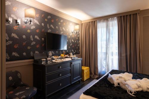 a hotel room with a bed and a tv on a wall at Hotel Spinale in Madonna di Campiglio