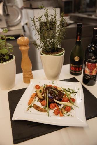 a plate of food on a table with bottles of wine at Wohlfühlhotel Innertalerhof in Gerlos